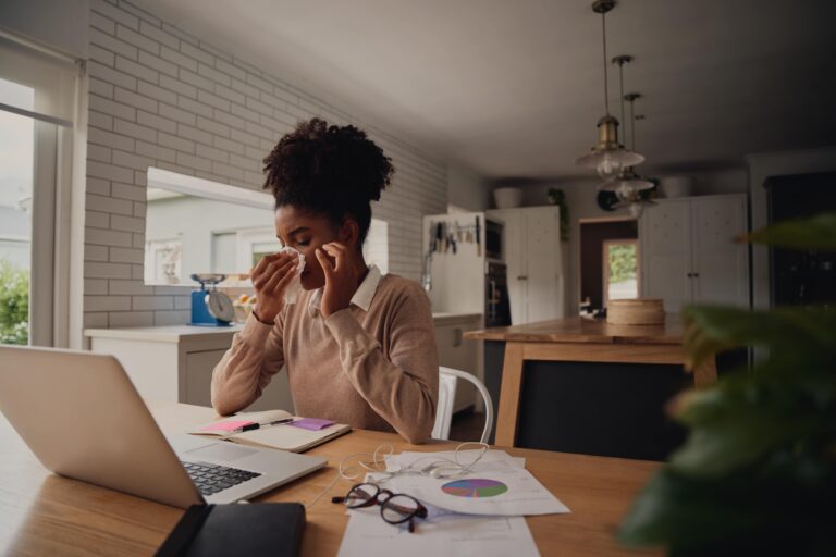 Woman blowing nose from allergens